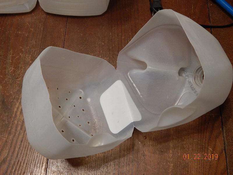 Milk jug cut open and drainage holes made